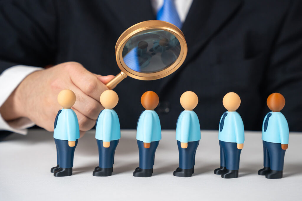 abusinessmanexaminesalineofjobapplicantsthrougha